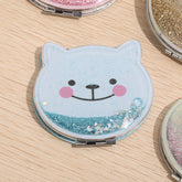 Upgrade your cosmetics collection with the Glitter Cat Pocket Double Sided Mirror. A leather looking base and a smiling feline face are covered by clear plastic, allowing for glitter to slide from side to side. It’s a little something pretty and a little something shiny to add boost to your day.
